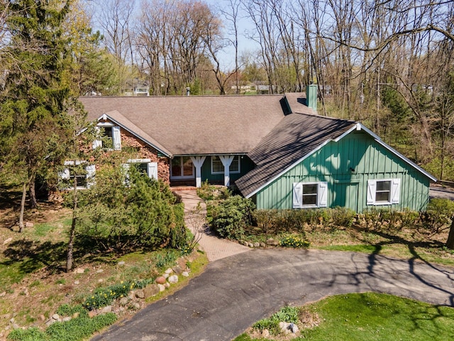view of front of property featuring board and batten siding and roof with shingles