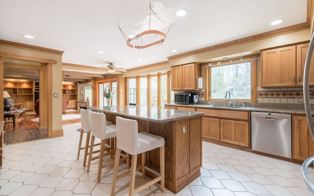 kitchen featuring a kitchen island, crown molding, tasteful backsplash, a sink, and stainless steel appliances