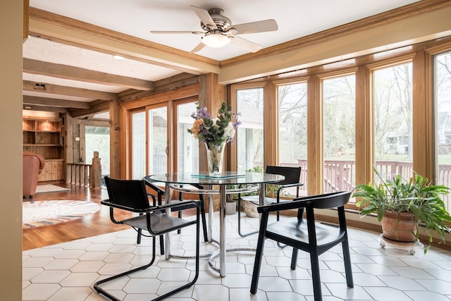 sunroom featuring beamed ceiling, plenty of natural light, and ornamental molding