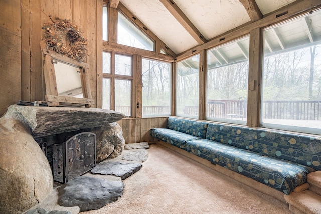 living room with carpet floors, beamed ceiling, a wealth of natural light, and high vaulted ceiling