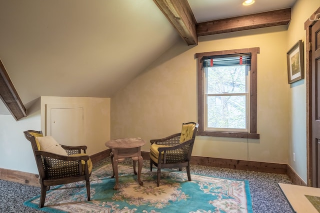living area featuring baseboards and lofted ceiling with beams