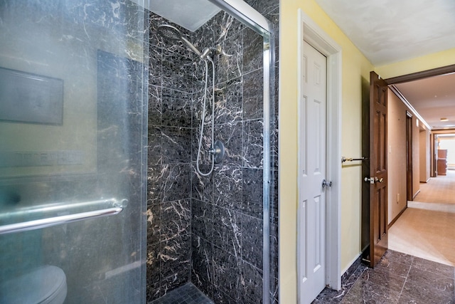 full bath featuring a stall shower and toilet