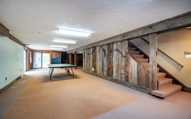 playroom featuring carpet floors, a textured ceiling, and baseboards