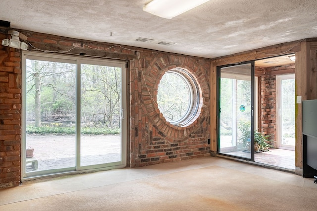 carpeted foyer with visible vents and a textured ceiling