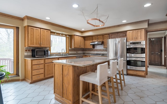 kitchen featuring crown molding, a sink, appliances with stainless steel finishes, and recessed lighting