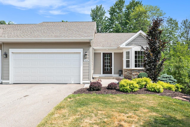 ranch-style home with a front lawn, roof with shingles, an attached garage, and aphalt driveway