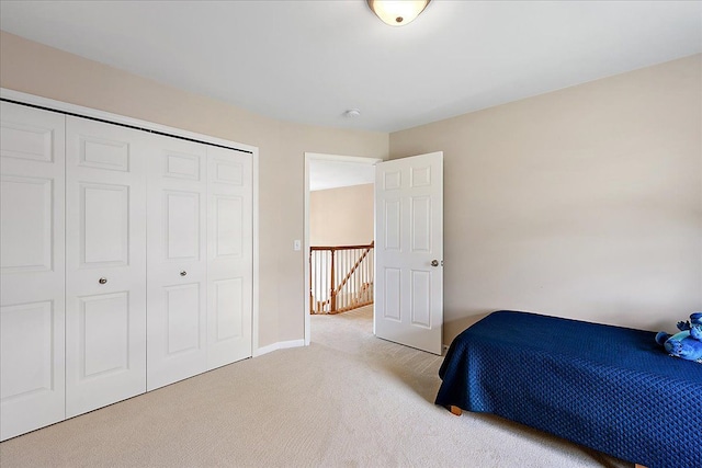bedroom with baseboards, carpet, and a closet