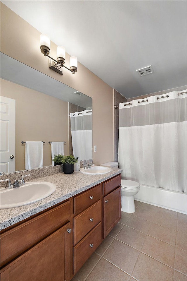 full bath featuring double vanity, tile patterned floors, visible vents, and a sink