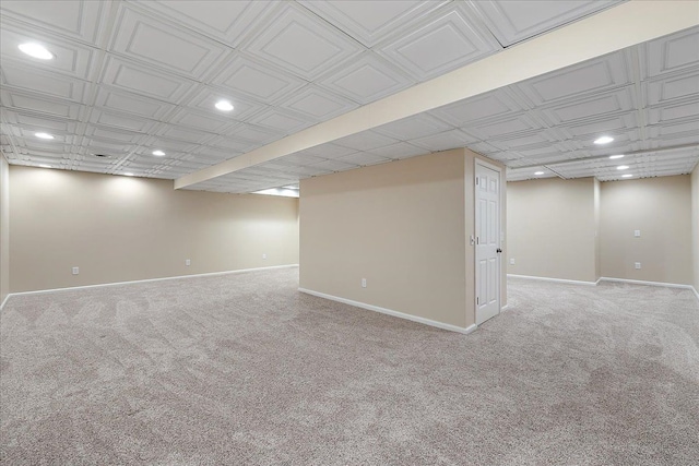 finished below grade area featuring carpet floors, baseboards, recessed lighting, and an ornate ceiling