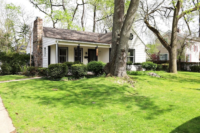 ranch-style house featuring a chimney and a front lawn