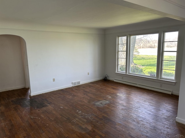 empty room featuring arched walkways, visible vents, dark wood-type flooring, and a baseboard radiator