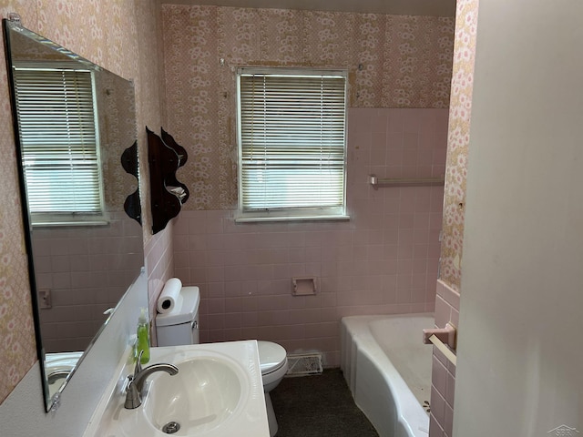 full bath with toilet, wallpapered walls, and a wealth of natural light