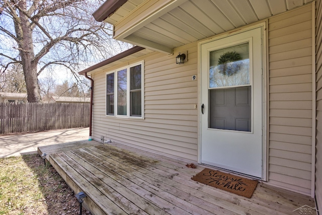 entrance to property with a wooden deck and fence