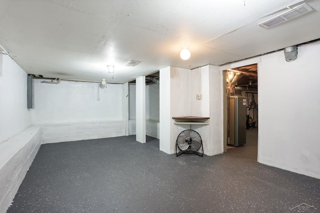 finished basement with visible vents and freestanding refrigerator