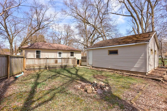 view of yard featuring an outbuilding, a wooden deck, and fence