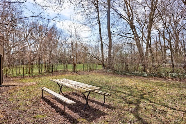 view of property's community with fence and a yard