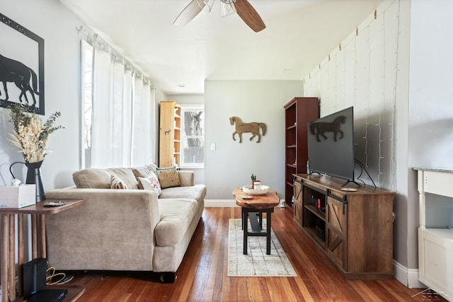 living room with ceiling fan, wood finished floors, and baseboards