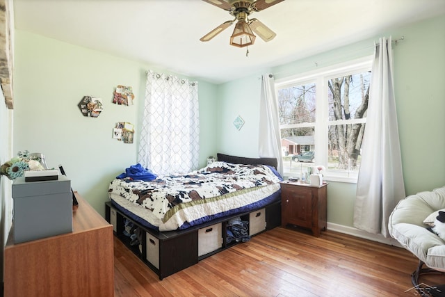 bedroom featuring ceiling fan, hardwood / wood-style flooring, and baseboards
