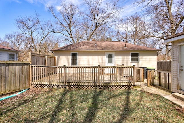 rear view of house featuring a lawn, a deck, and a fenced backyard