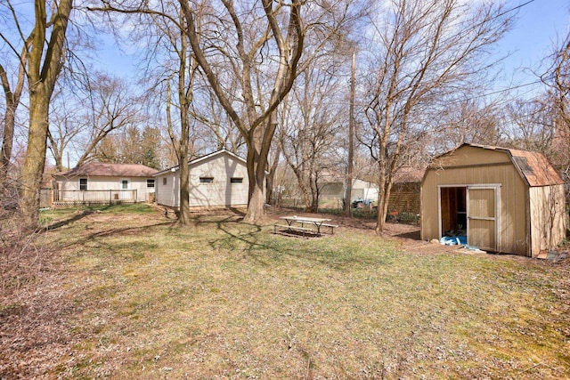 view of yard featuring an outbuilding, a detached garage, and a shed