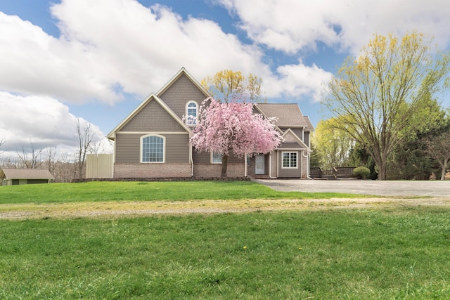 view of front of house with a front lawn and brick siding