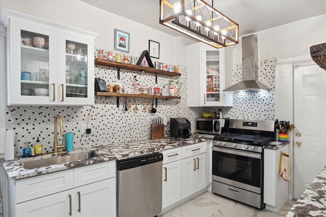 kitchen featuring light stone counters, a sink, wall chimney exhaust hood, marble finish floor, and stainless steel appliances