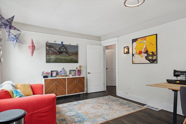 living area featuring baseboards, visible vents, and dark wood-style floors