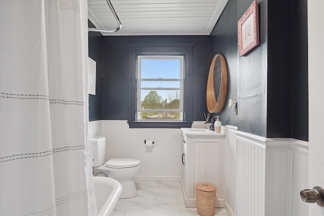 full bath featuring a shower with curtain, a wainscoted wall, vanity, toilet, and marble finish floor