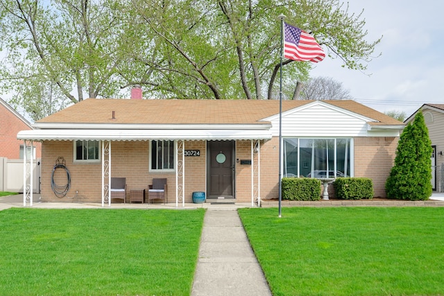 single story home featuring brick siding, a chimney, fence, and a front yard