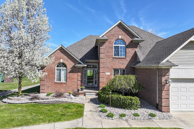 1355 Ridge View Ct, Grand Blanc, MI 48439 - traditional-style home with a garage, a shingled roof, a front yard, and brick siding