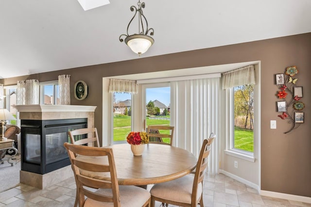 1355 Ridge View Ct, Grand Blanc, MI 48439 - dining space with baseboards, a skylight, a tiled fireplace, and stone tile flooring