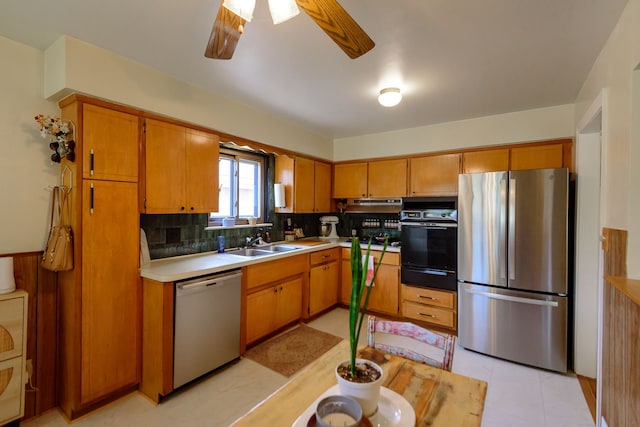 kitchen with decorative backsplash, ceiling fan, a sink, appliances with stainless steel finishes, and a warming drawer