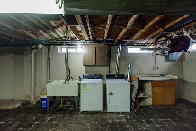 washroom featuring a sink, washer and clothes dryer, cabinet space, and a wealth of natural light