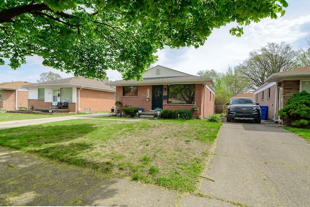 bungalow-style home featuring a front lawn and brick siding