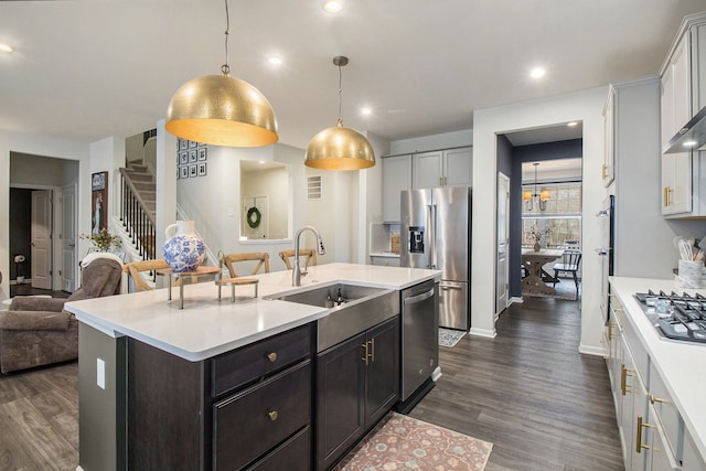 2670 Ironton Dr, Commerce Twp, MI 48382 - kitchen featuring appliances with stainless steel finishes, light countertops, a sink, dark wood-style floors, and open floor plan
