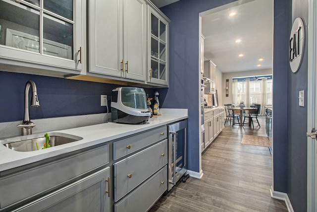 2670 Ironton Dr, Commerce Twp, MI 48382 - kitchen featuring gray cabinets, light countertops, a sink, dark wood-type flooring, and wine cooler