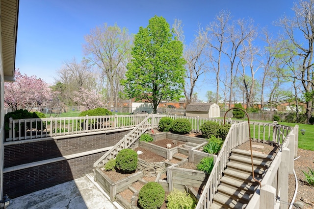 view of yard with a vegetable garden, an outbuilding, a fenced backyard, and a shed