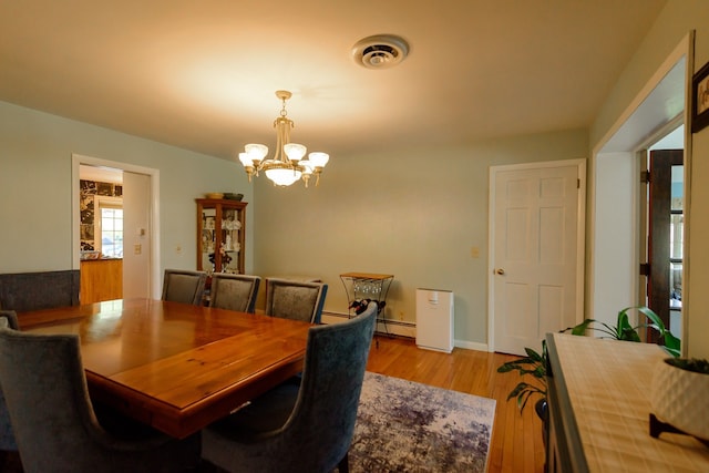 dining area featuring visible vents, baseboards, light wood-type flooring, a chandelier, and a baseboard radiator