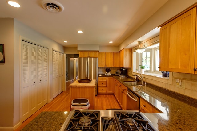 kitchen with visible vents, a sink, appliances with stainless steel finishes, and tasteful backsplash