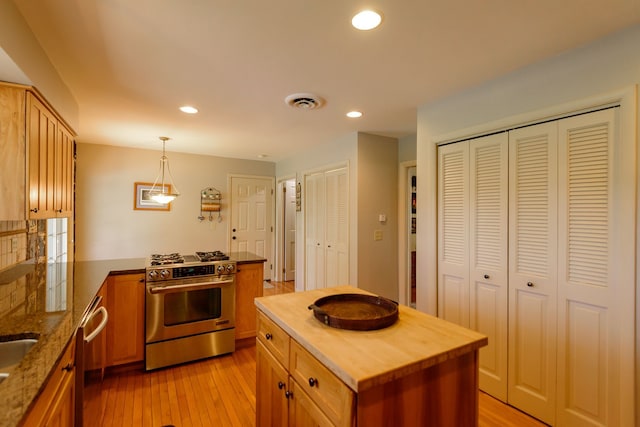kitchen with light wood-style floors, recessed lighting, wood counters, appliances with stainless steel finishes, and hanging light fixtures
