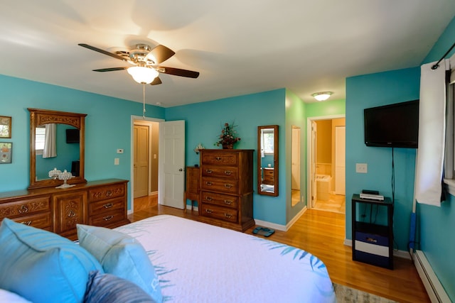 bedroom featuring ceiling fan, wood finished floors, baseboards, a baseboard radiator, and ensuite bath