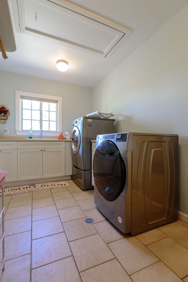 laundry room with laundry area, attic access, light tile patterned floors, a sink, and washer and dryer