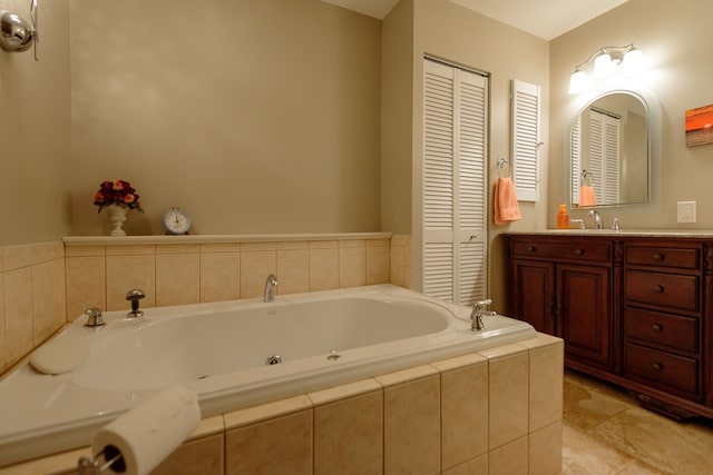 full bathroom with a tub with jets, a closet, and vanity