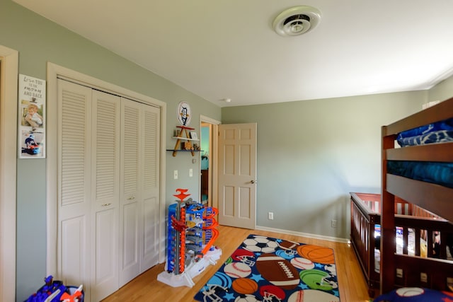 bedroom featuring visible vents, wood finished floors, and a closet