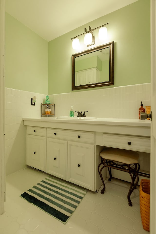 bathroom with tile walls, a wainscoted wall, and vanity
