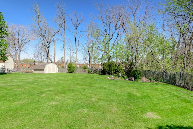 view of yard featuring a storage shed, an outdoor structure, and a fenced backyard