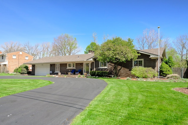 ranch-style home featuring brick siding, a garage, aphalt driveway, and a front yard