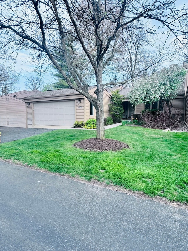 ranch-style house featuring a garage, driveway, and a front yard