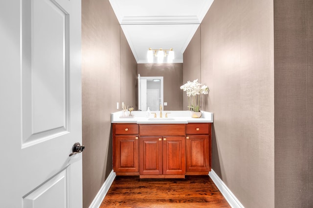 bathroom with ornamental molding, vanity, wood finished floors, and baseboards