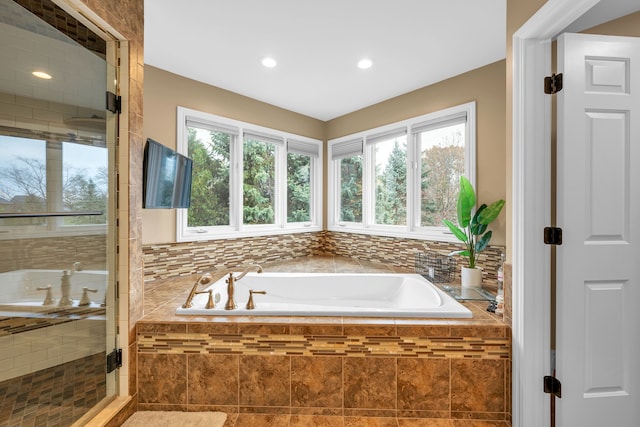 full bath with a stall shower, recessed lighting, and a bath